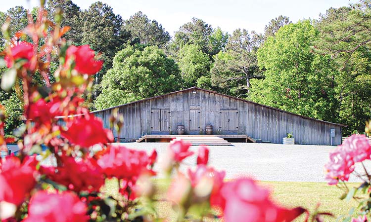 Old barn with red flowers in front