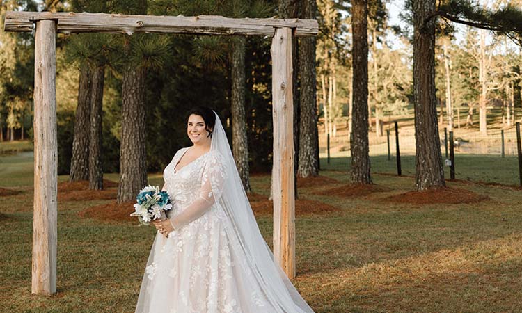 Bride standing under marriage arch.